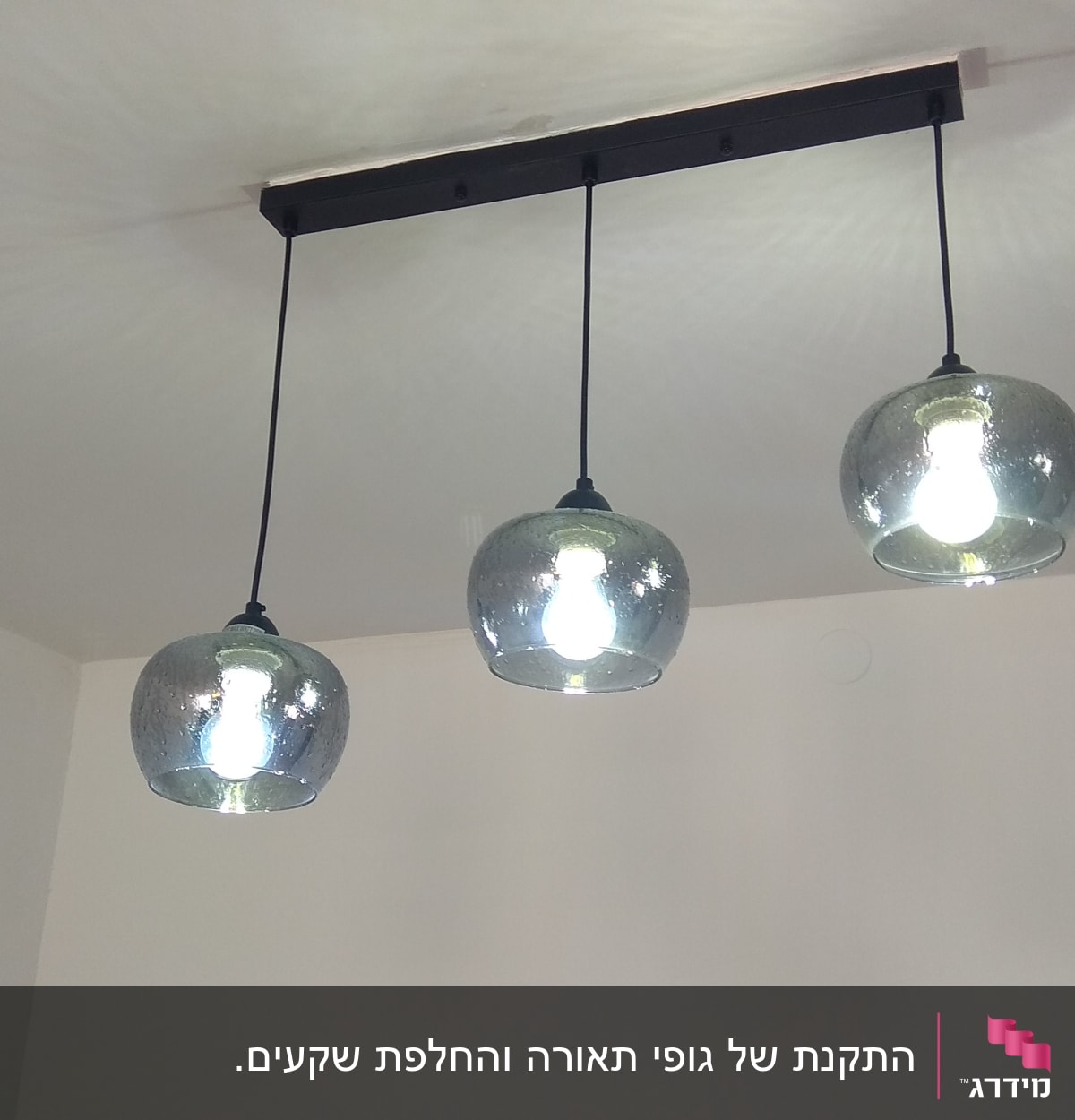 שלושה גופי תאורה תלויים עם נורות דולקות